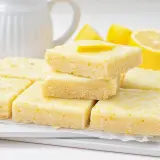 Deliciosos brownie de limón, con una capa superior glaseada y ralladura de limón.