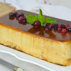 Deliciosa tarta de la abuela con sobaos, cubierta de caramelo y decorada con frutos rojos y menta.
