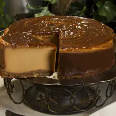 Tarta de dulce de leche, cremosa y dorada, con un glaseado brillante que invita a probarla.