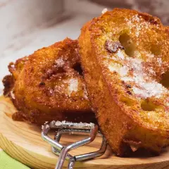 Dos deliciosas torrijas espolvoreadas con azúcar, listas para disfrutar. Perfectas para tu receta de torrijas con miel.