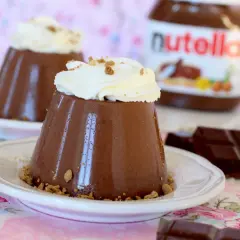 Deliciosa panna cotta de Nutella, coronada con crema batida y migas crujientes. Un postre irresistible.