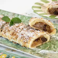 Deliciosa trenza de hojaldre rellena de manzana y pasas, espolvoreada con azúcar glas y nueces picadas.