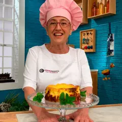 Eva Arguiñano sonríe mostrando una deliciosa tarta de queso casera, decorada con menta fresca.