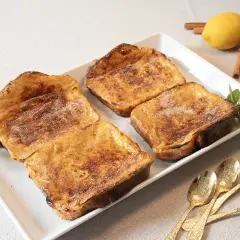 Cuatro deliciosas torrijas al horno, espolvoreadas con azúcar y canela, listas para disfrutar.