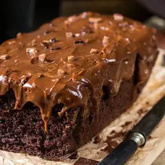 Deliciosa coca de chocolate casera, cubierta con glaseado de chocolate y trocitos de cacao. Perfecta para un antojo dulce.