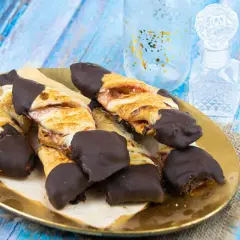 Deliciosos lazos de hojaldre con relleno de fresa, bañados en chocolate negro. Un dulce tentempié perfecto.