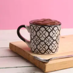 Taza con un delicioso oreo mug cake, lista para disfrutar con una cuchara.