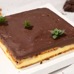Deliciosa tarta de galletas y chocolate, con capas de crema y cubierta de chocolate brillante, decorada con menta fresca.
