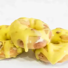 Tres rosquillas de San Isidro cubiertas con un glaseado amarillo brillante, listas para disfrutar.