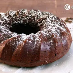 Bizcocho de café oscuro, con forma de rosca, espolvoreado con azúcar glas. Perfecto para acompañar un café.