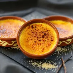 Tres deliciosas cremas catalanas recién hechas, con su capa crujiente de caramelo tostado, listas para ser disfrutadas.
