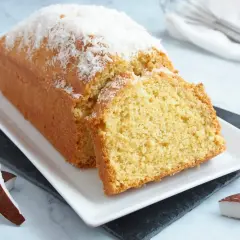 Bizcocho de coco esponjoso, cubierto con coco rallado y acompañado de trozos de coco fresco. ¡Un postre tropical delicioso!