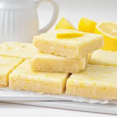 Deliciosos brownie de limón, con una capa superior glaseada y ralladura de limón.