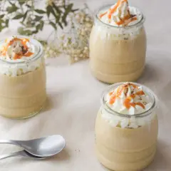 Delicioso mousse de café en vasitos, coronado con crema batida, caramelo y cacao. ¡Perfecto para un postre!