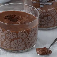 Delicioso mousse de nata de chocolate en copas decoradas. Una cucharada lista para saborear.