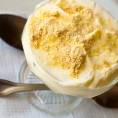 Delicioso postre de serradura portuguesa en copa, cubierto con migas de galleta.