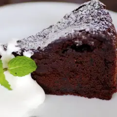 Un trozo de bizcocho de chocolate esponjoso con yogur y menta, espolvoreado con azúcar glas.