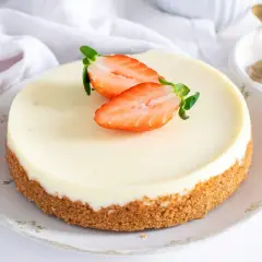 Tarta de cuajada cremosa con base crujiente y fresas frescas. Un postre delicioso y elegante.
