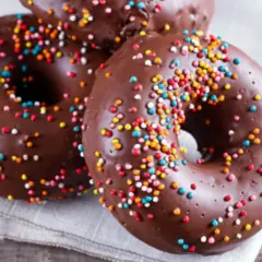 Deliciosos donuts de calabaza y chocolate cubiertos con chispas de colores, listos para disfrutar.