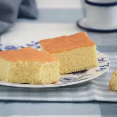Dos porciones de pa de pessic esponjoso y dorado en un plato con diseño floral azul.