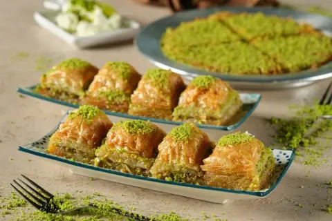 Delicioso baklava, una receta tradicional con capas crujientes y relleno de pistacho, espolvoreado con más pistacho verde.