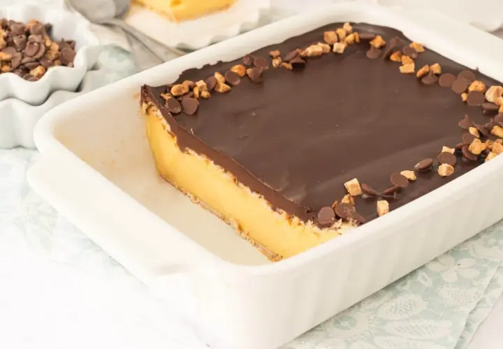 Tarta de galletas de la abuela de toda la vida, con capa de crema y cobertura de chocolate, decorada con trocitos de galleta y chocolate.