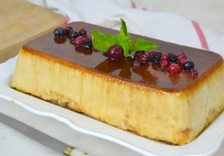 Deliciosa tarta de la abuela con sobaos, cubierta de caramelo y decorada con frutos rojos y menta.