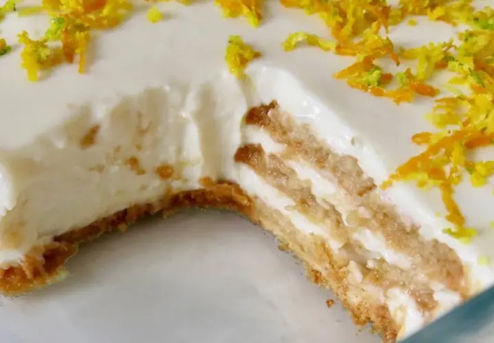 Tarta de limón sin horno, con capas de galleta y crema, decorada con ralladura de limón y naranja.