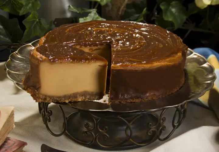 Tarta de dulce de leche, cremosa y dorada, con un glaseado brillante que invita a probarla.
