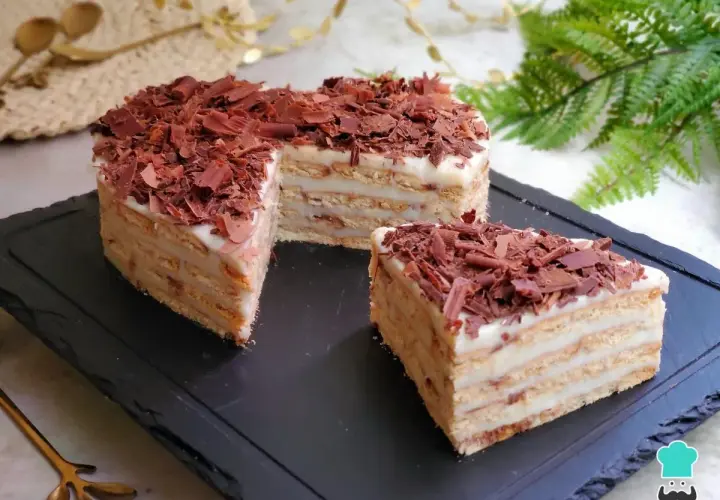 Deliciosa tarta del abuelo, con capas de galleta y crema, cubierta de virutas de chocolate. ¡Un postre casero irresistible!