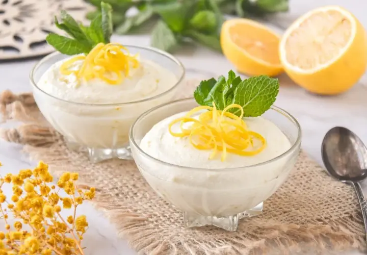 Delicioso mousse de limón con leche condensada, decorado con ralladura de limón y menta fresca.