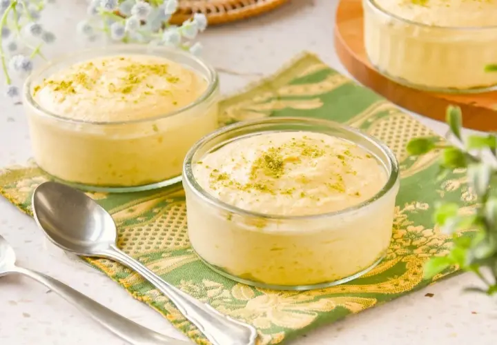 Delicioso mousse de mango en copas de cristal, espolvoreado con ralladura verde.