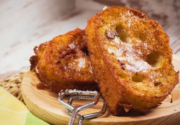 Dos deliciosas torrijas espolvoreadas con azúcar, listas para disfrutar. Perfectas para tu receta de torrijas con miel.
