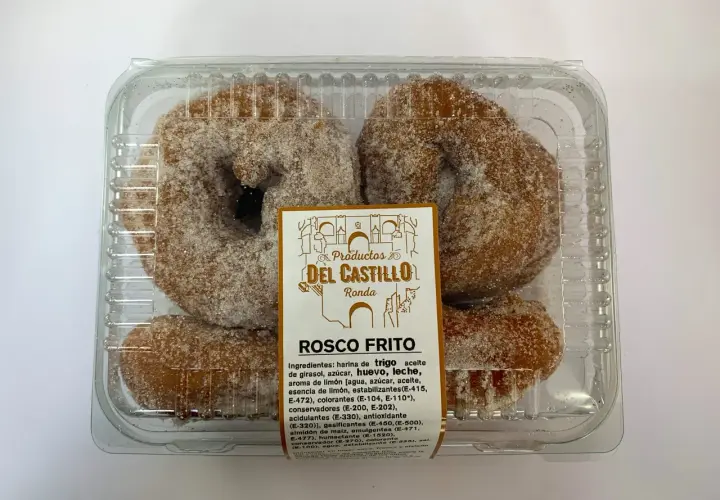 Roscos fritos azucarados en un envase transparente. La etiqueta indica "Productos Del Castillo Ronda" y "Rosco Frito".
