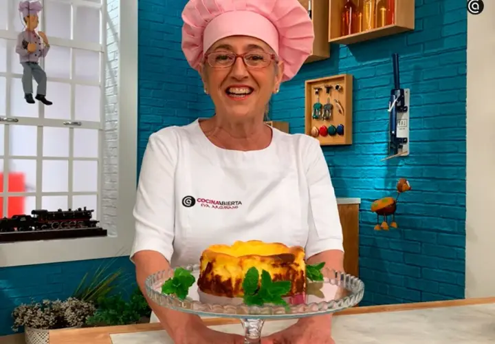 Eva Arguiñano sonríe mostrando una deliciosa tarta de queso casera, decorada con menta fresca.
