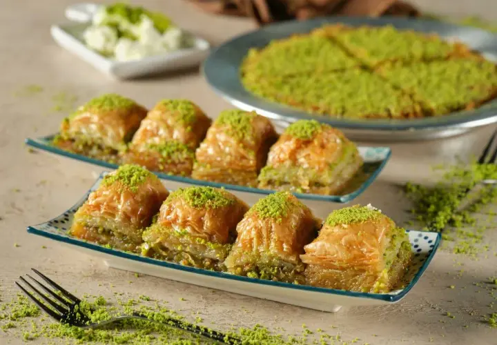 Delicioso baklava, una receta tradicional con capas crujientes y relleno de pistacho, espolvoreado con más pistacho verde.