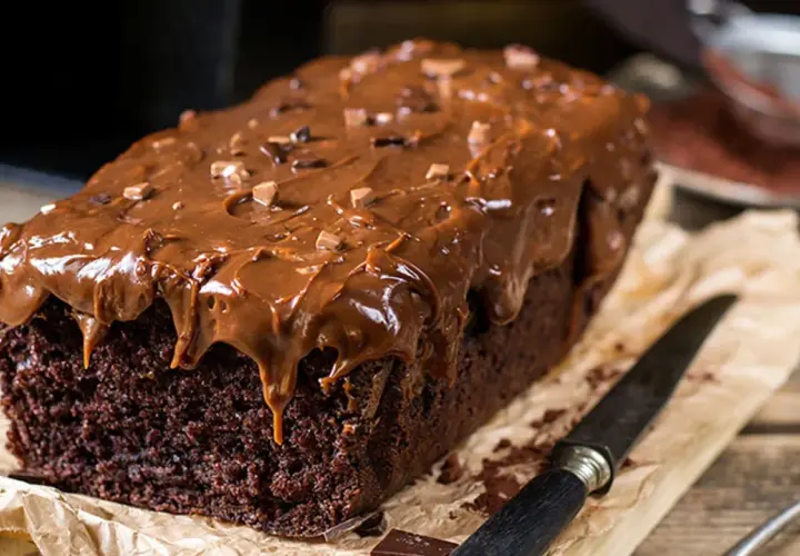 Deliciosa coca de chocolate casera, cubierta con glaseado de chocolate y trocitos de cacao. Perfecta para un antojo dulce.