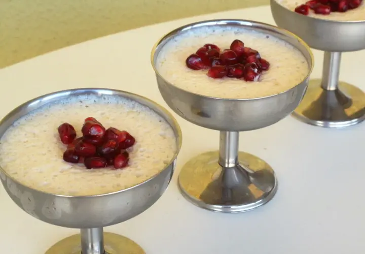 Delicioso mousse de leche condensada Thermomix, coronado con granada, servido en copas metálicas.