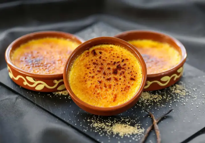 Tres deliciosas cremas catalanas recién hechas, con su capa crujiente de caramelo tostado, listas para ser disfrutadas.