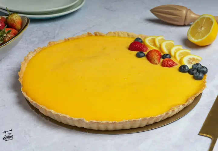 La mejor tarta de limón, con una crema amarilla vibrante y decorada con fresas, arándanos y rodajas de limón. ¡Un postre irresistible!