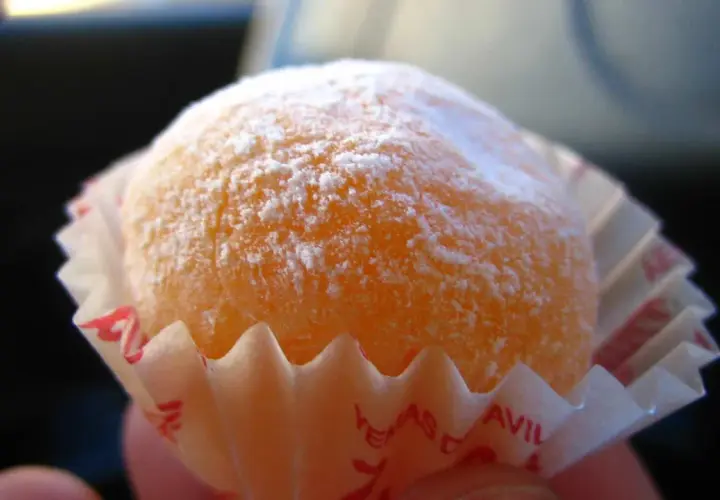 Dulce naranja cubierto de azúcar glas, listo para disfrutar. Una delicia que recuerda a la yemas de Santa Teresa receta.