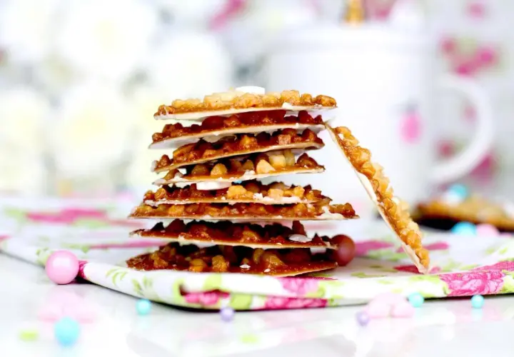 Deliciosas moscovitas receta, crujientes y doradas, apiladas sobre un mantel floral.