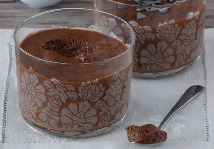 Delicioso mousse de nata de chocolate en copas decoradas. Una cucharada lista para saborear.