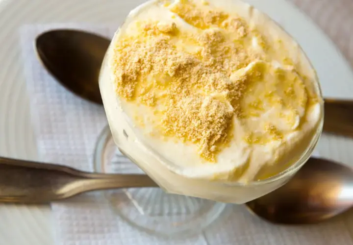 Delicioso postre de serradura portuguesa en copa, cubierto con migas de galleta.