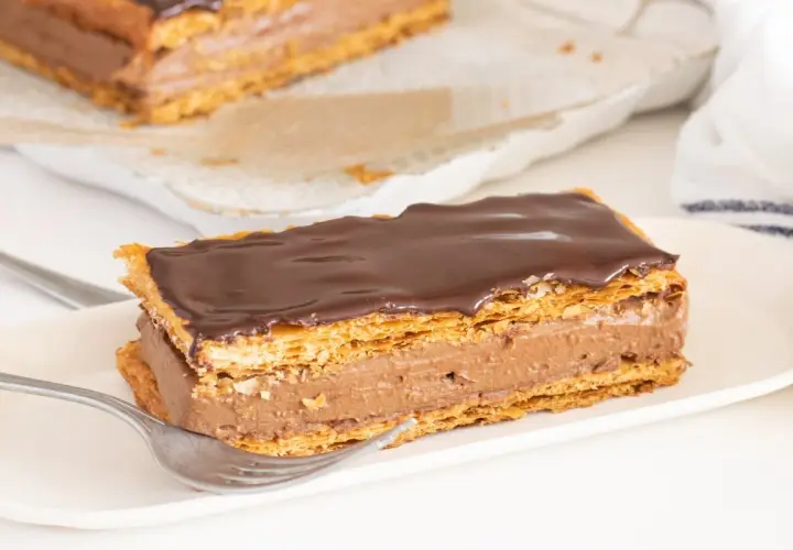 Delicioso milhojas de chocolate con capas crujientes de hojaldre y crema de cacao, listo para disfrutar.