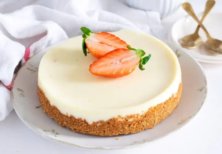 Tarta de cuajada cremosa con base crujiente y fresas frescas. Un postre delicioso y elegante.