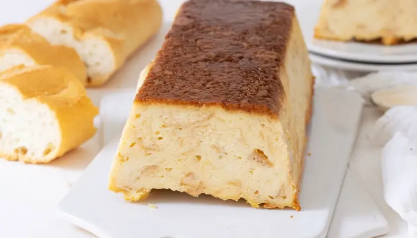 Un delicioso pudin de pan duro, con trozos de pan crujiente y una cobertura dorada.