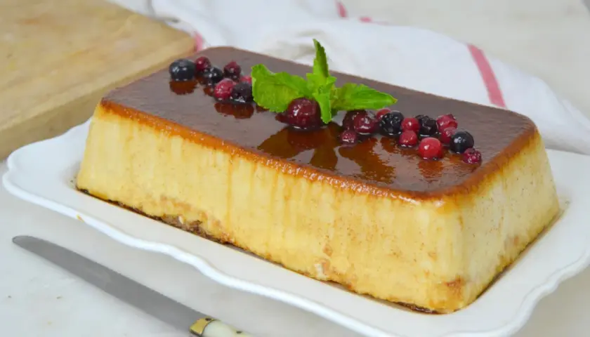 Deliciosa tarta de la abuela con sobaos, cubierta de caramelo y decorada con frutos rojos y menta.