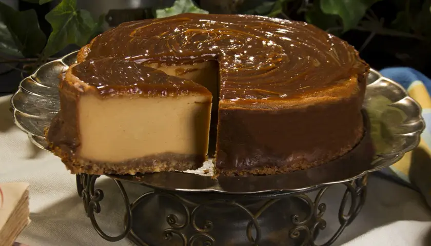 Tarta de dulce de leche, cremosa y dorada, con un glaseado brillante que invita a probarla.
