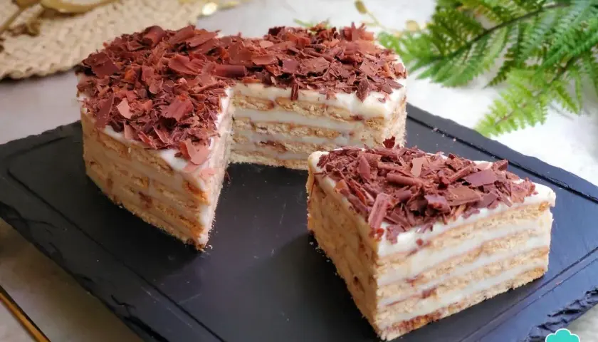 Deliciosa tarta del abuelo, con capas de galleta y crema, cubierta de virutas de chocolate. ¡Un postre casero irresistible!